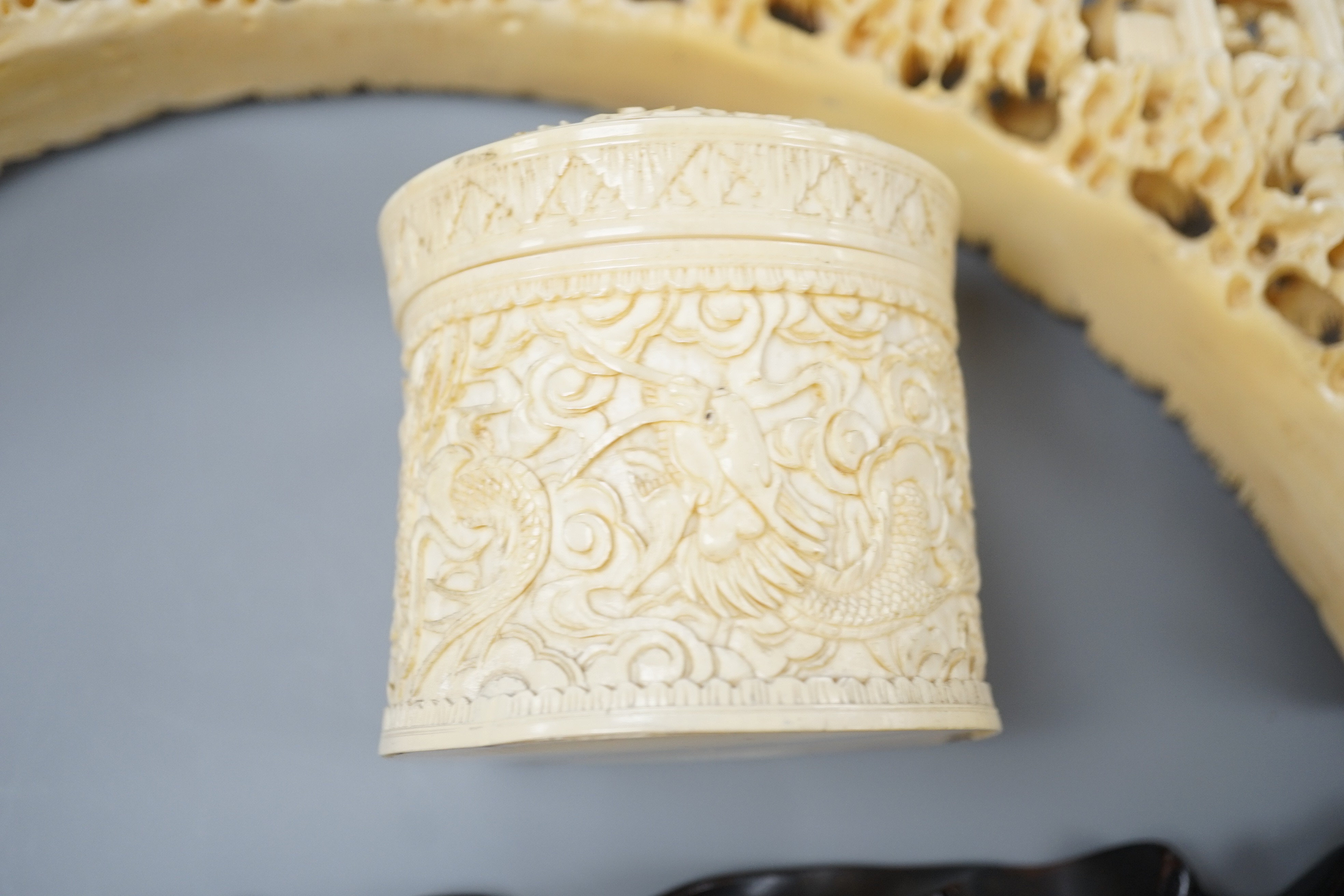 An early 20th century Chinese ivory ‘dragon’ box and cover, and a boar’s tusk carving of figures amid pavilions 40cm